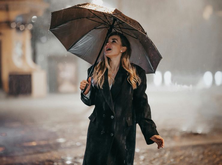 donna con ombrello sotto la pioggia