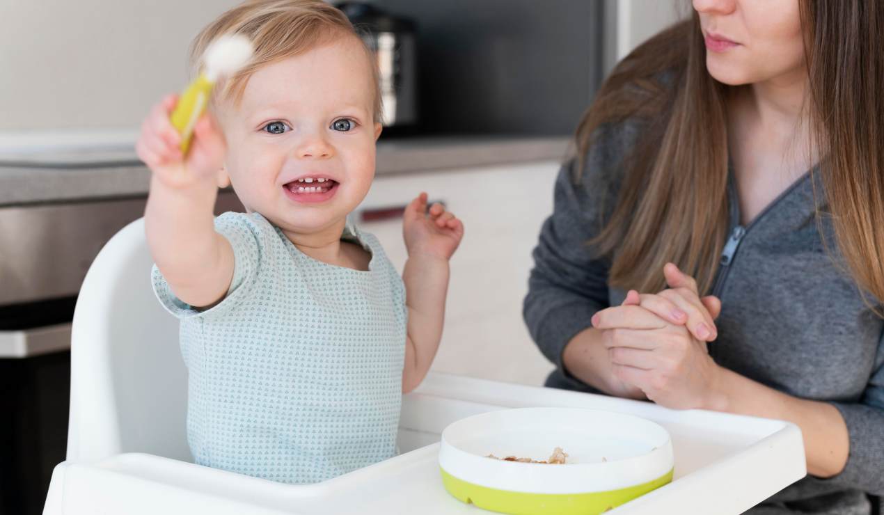 Bambino con cucchiaino in mano accanto alla madre - fonte_Freepik.com - Unadonna.it